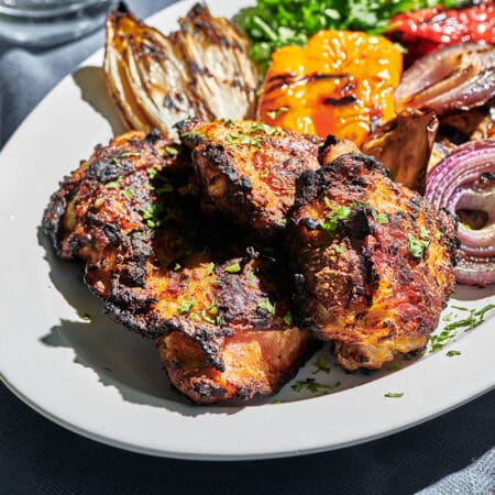 Grilled curry-marinated chicken thighs on plate