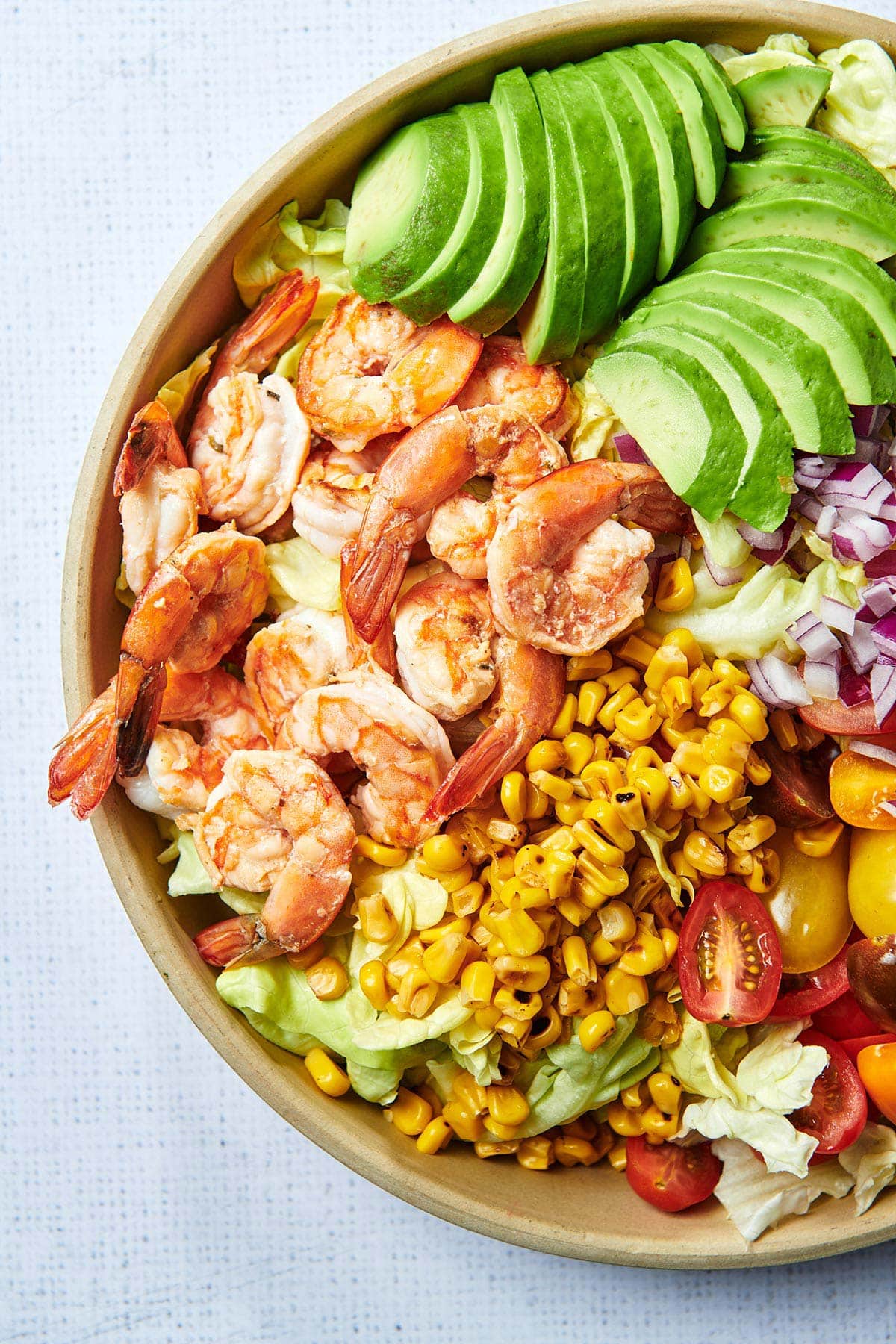 Grilled Shrimp Salad with avocado and grilled corn in brown bowl.
