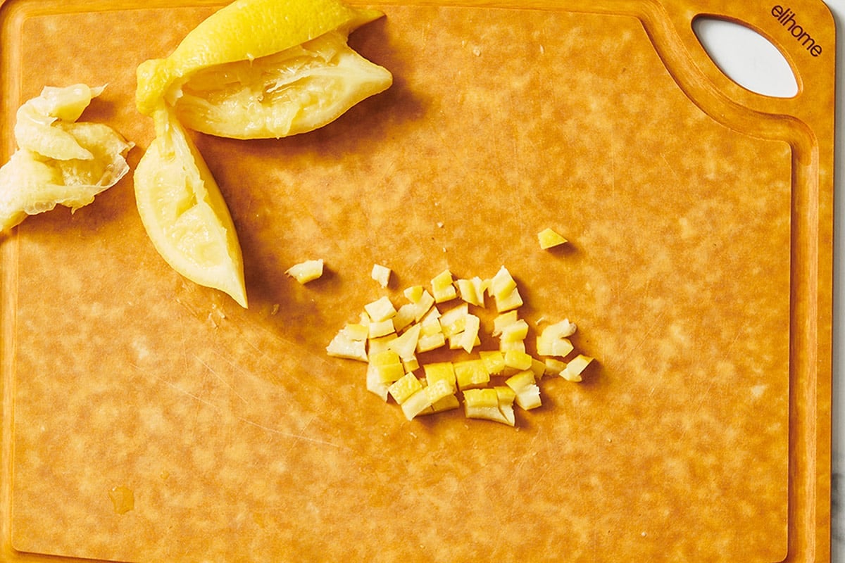 Homemade preserved lemons on wood cutting board.