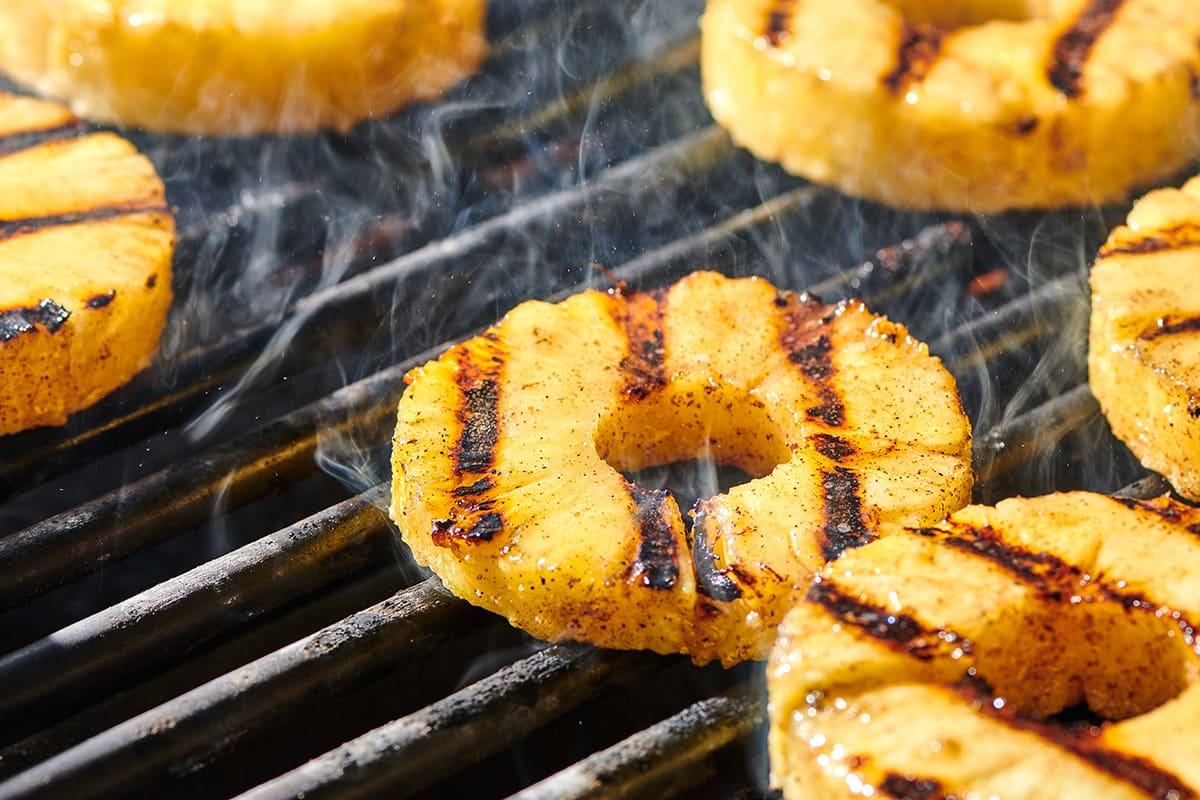 Pineapple rings cooking on a hot grill.