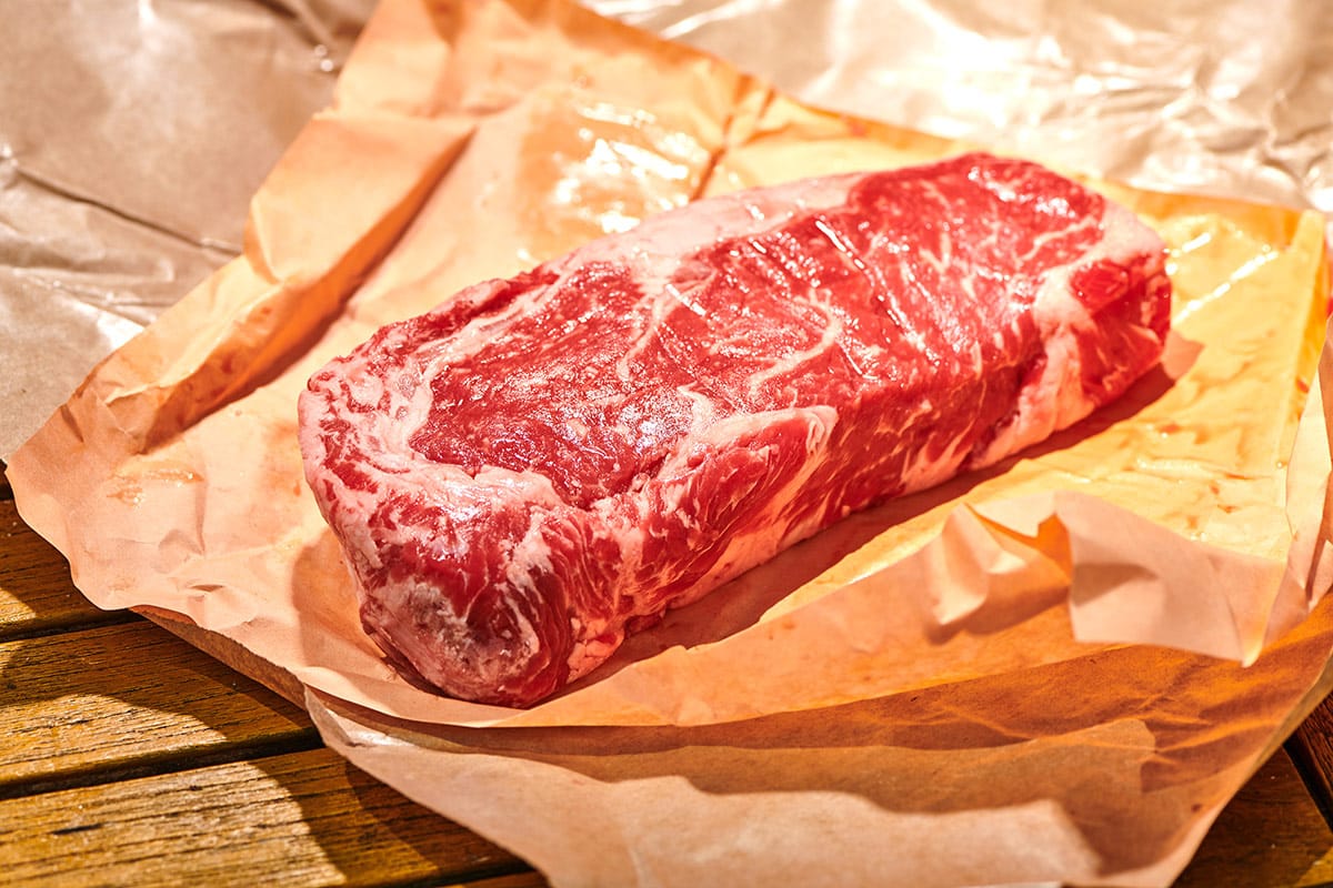 Raw rib-eye steak on butcher paper.