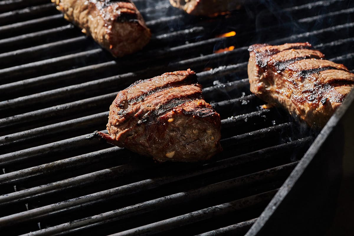Top sirloins steak on hot grill.