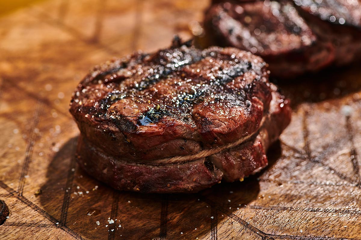 Grilled filet mignon on cutting board.