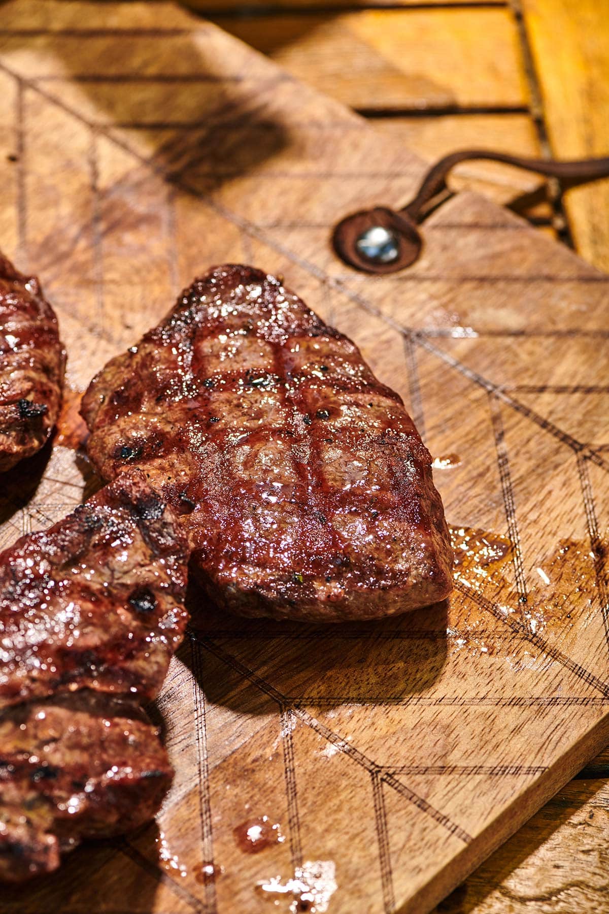 Grilled Flat Iron Steaks on wood cutting board.