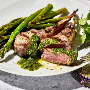 Rib lamb chops with pesto and asparagus on cookout plate.