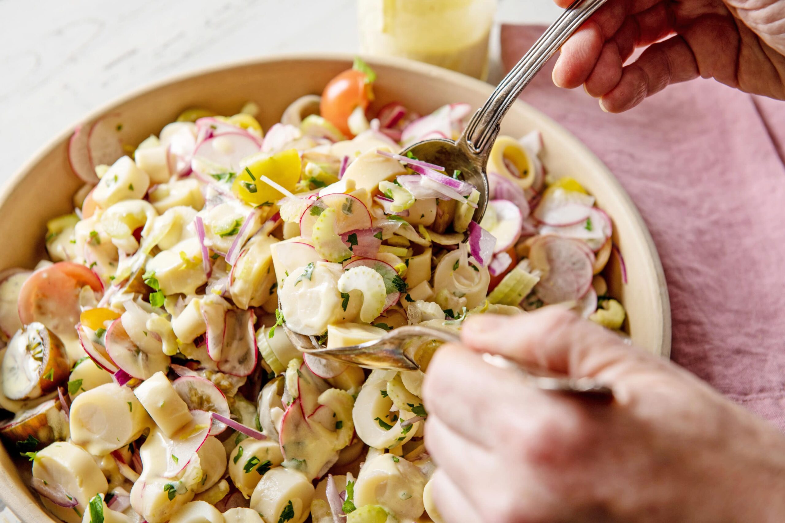 Tossing Hearts of Palm Salad in bowl.