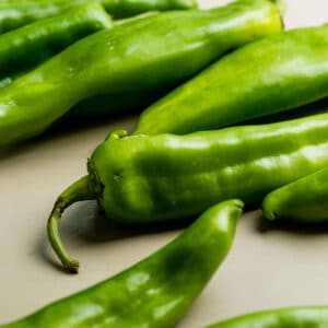 Fresh Hatch chiles laying out on white table.