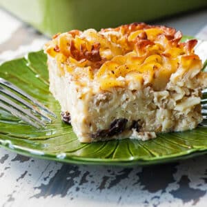 Slice of Jewish Noodle Kugel on green plate with fork.