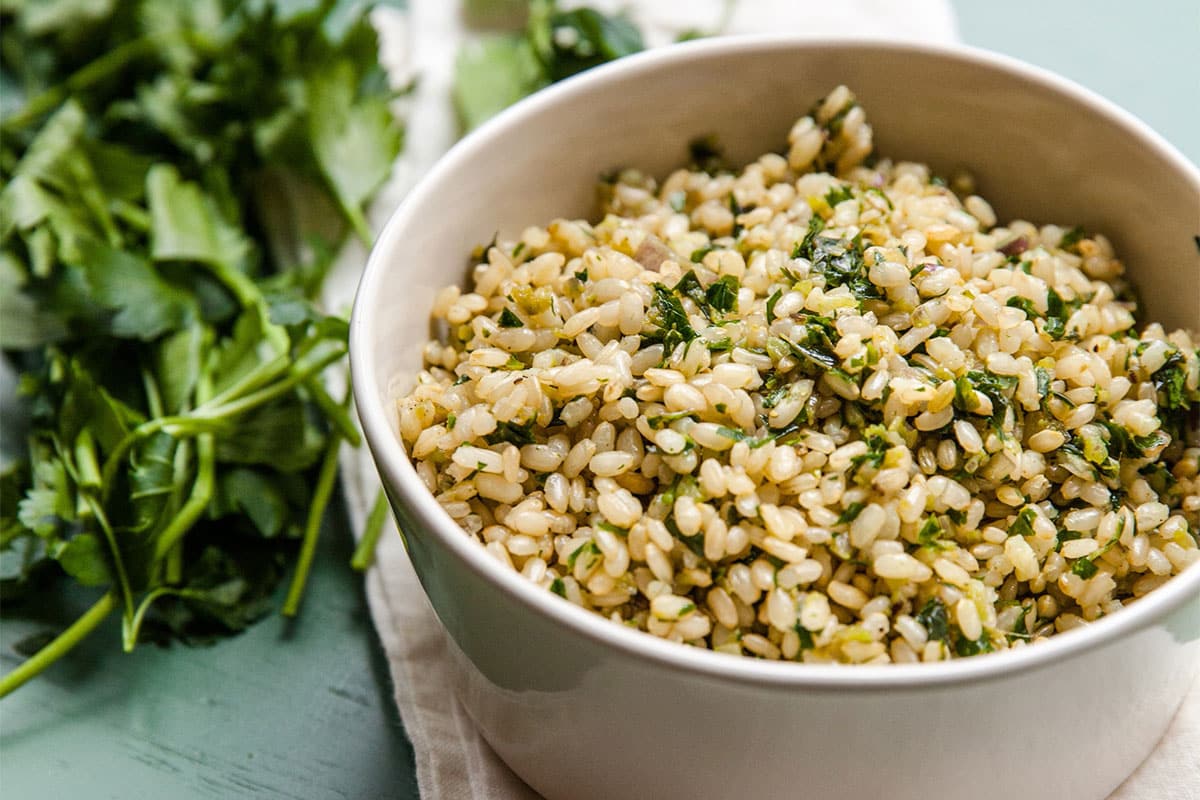 Herby Brown Rice in white bowl on napkin.