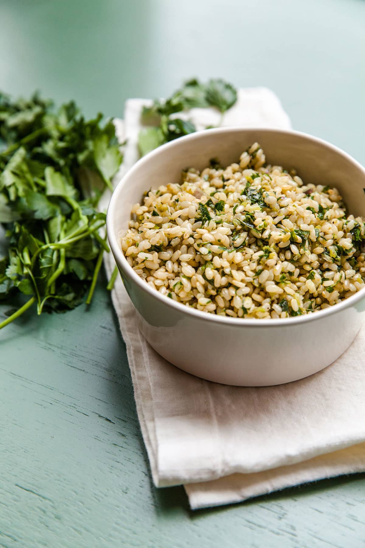 Herby Brown Rice in white bowl on napkin.