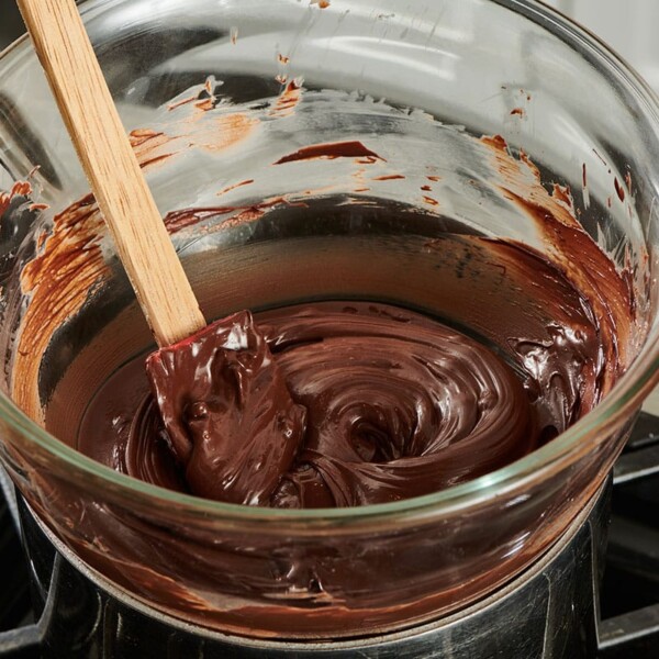 Chocolate melted in a homemade double boiler on the stove.