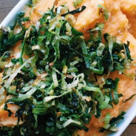 Mashed Yukon and Sweet Potatoes with Sauteed Leeks in white serving dish.