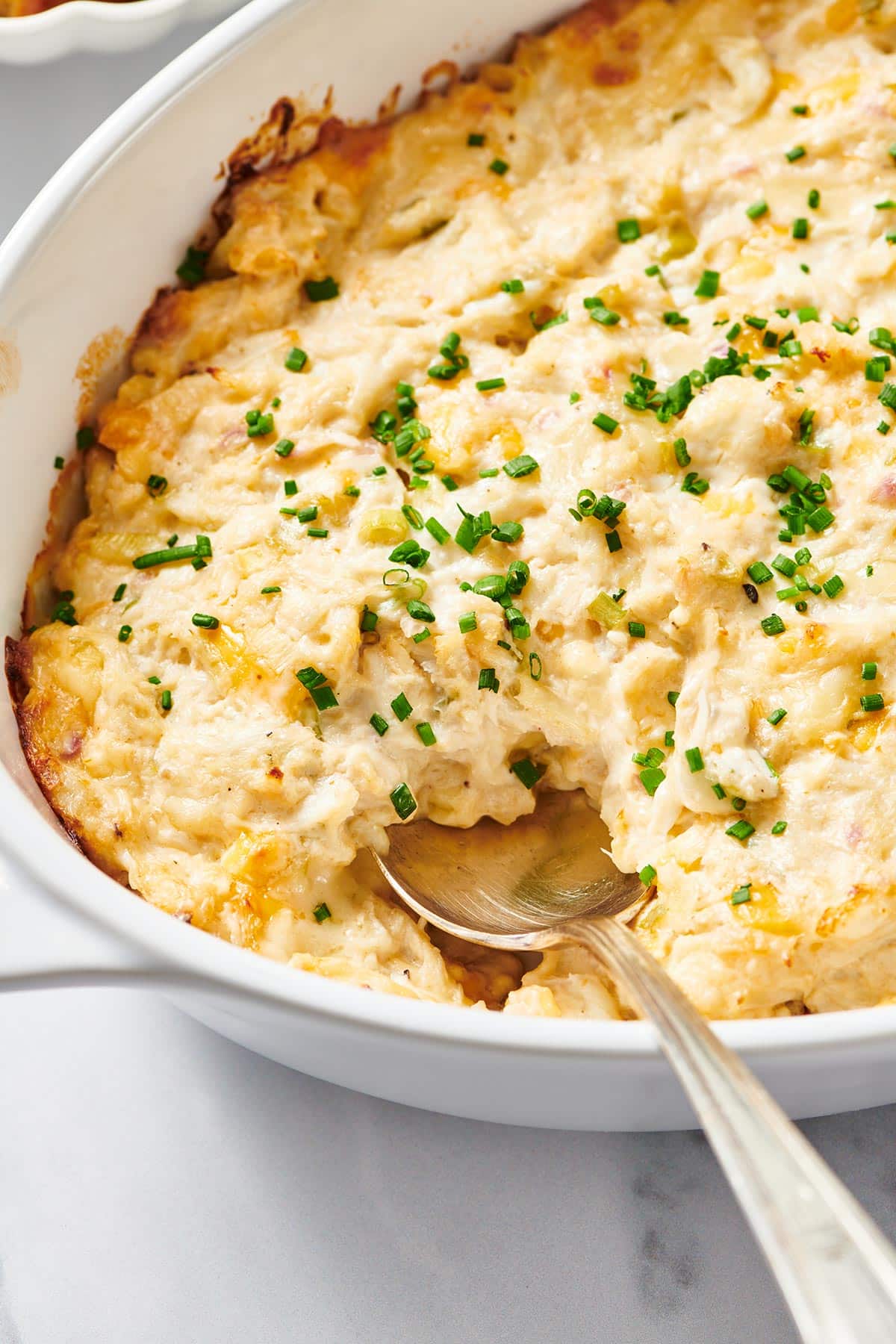 Baked hot crab dip in dish with spoon.