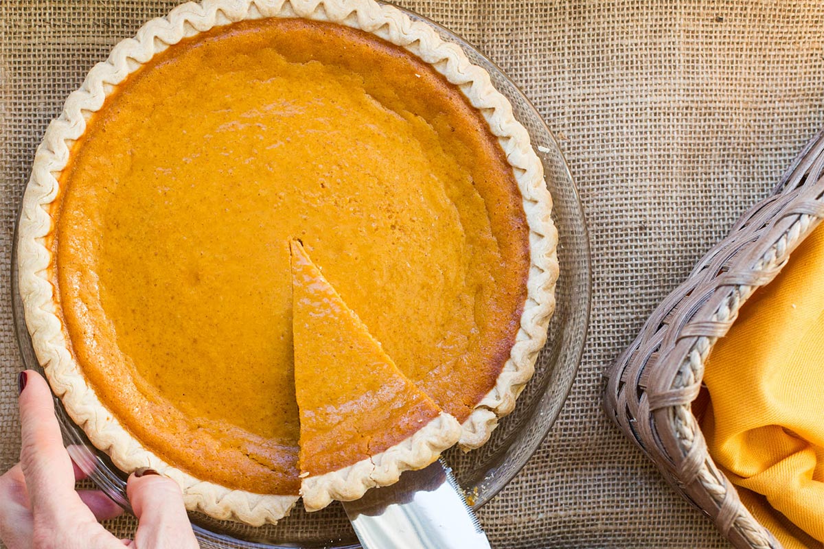 Cutting slice of Sweet Potato Pie from pan.