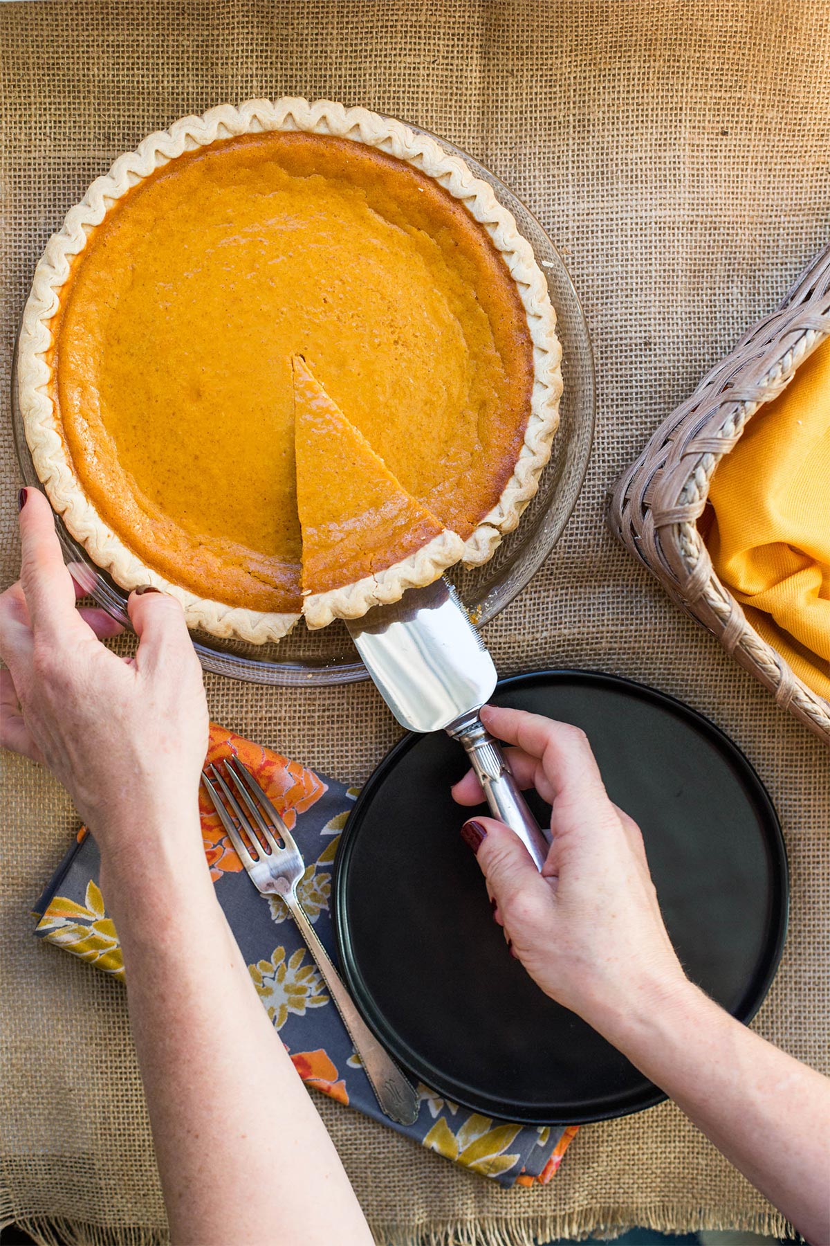 Woman serving up a slice of sweet potato pie.