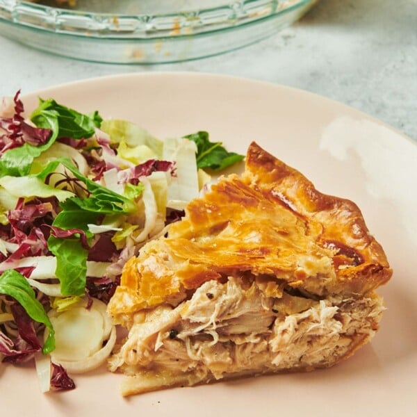 Slice of Moravian chicken pie on plate with salad.