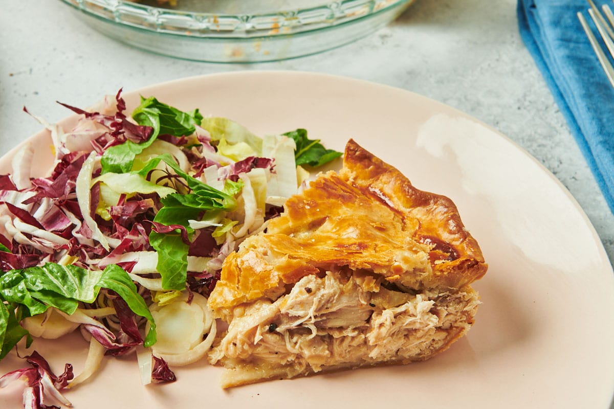 Slice of Moravian chicken pie on plate with salad.