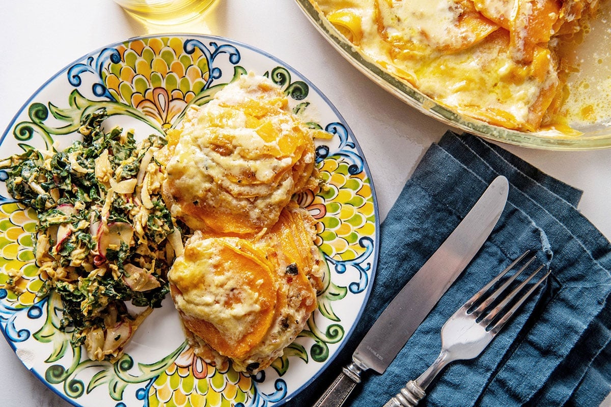Scalloped Sweet Potatoes on plate with salad.