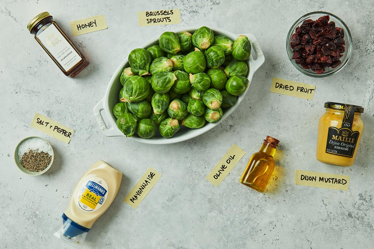 Brussels sprouts, honey, mustard, and other ingredients on marble.