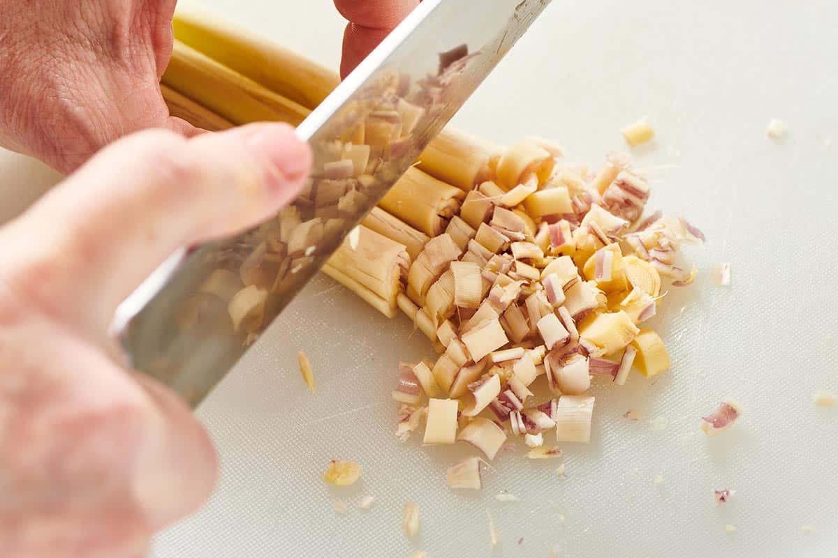 Chopping fresh lemongrass with chef knife.