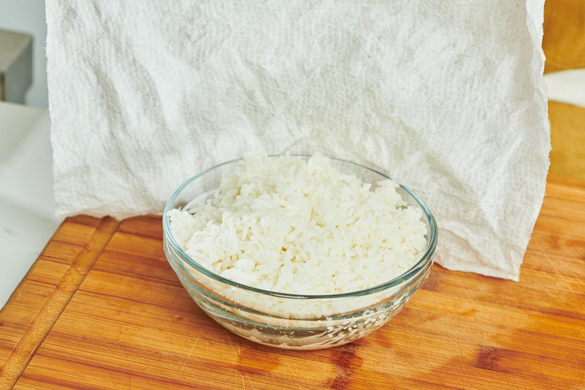 Covering glass bowl of rice with damp paper towel.