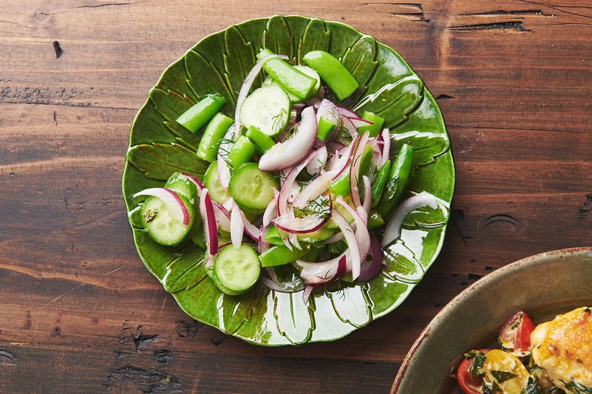 Sugar snap pea salad on green plate.