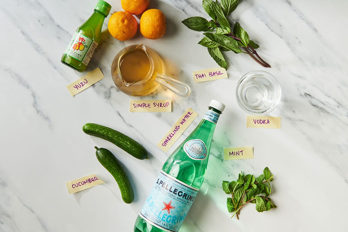 Yuzu juice, simple syrup, sparkling water, fresh herbs, and other ingredients for big-batch yuzu cocktails.