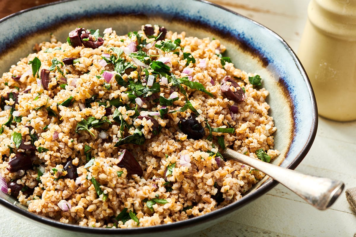 Bulgur wheat salad in bowl with serving spoon.