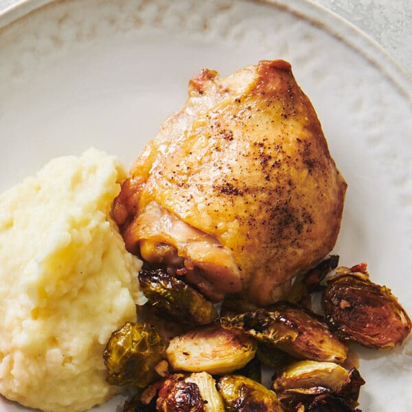 Baked chicken thigh on plate.