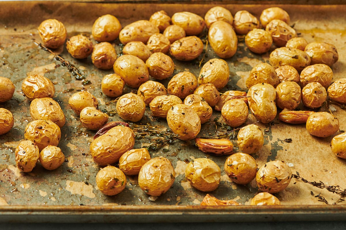 Potatoes roasted in duck fat on parchment-lined baking sheet.
