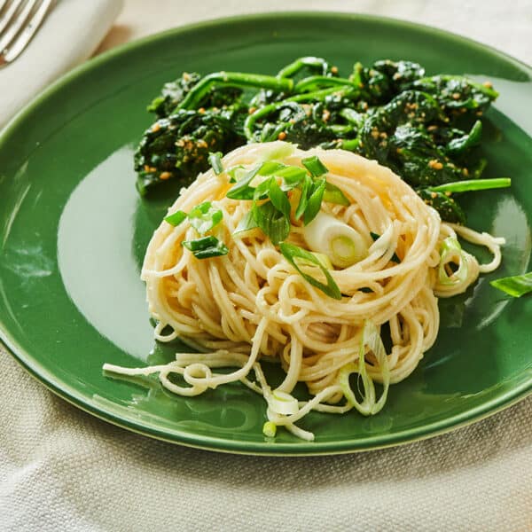 Vietnamese Garlic Noodles piled on green plate with sides.