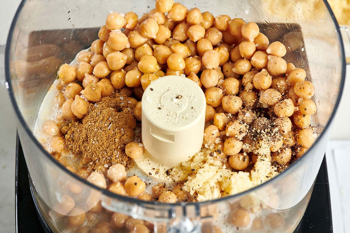 Chickpeas and seasonings in food processor.