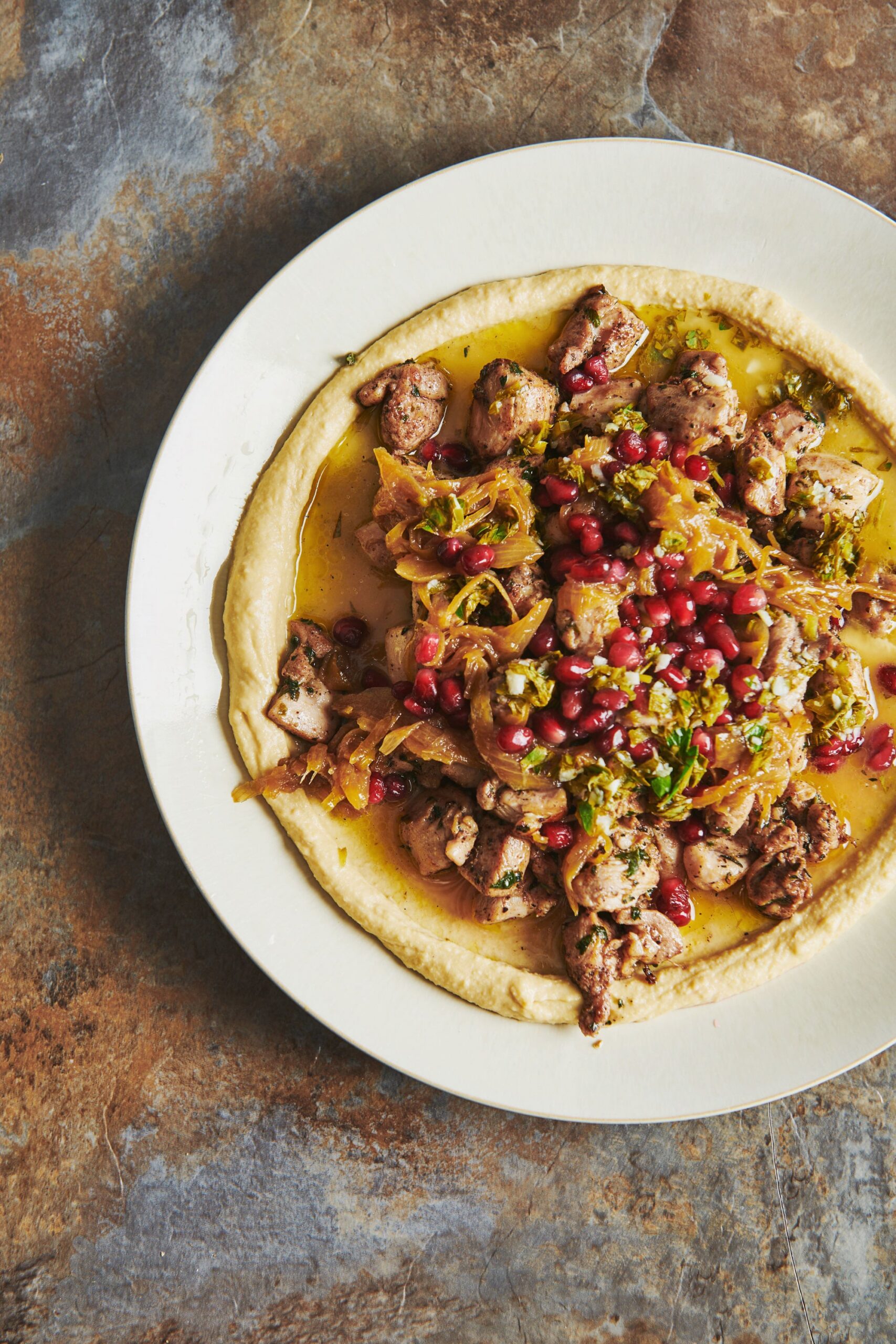 Plate of Chicken Kawarma with Lemon Sauce over Hummus.