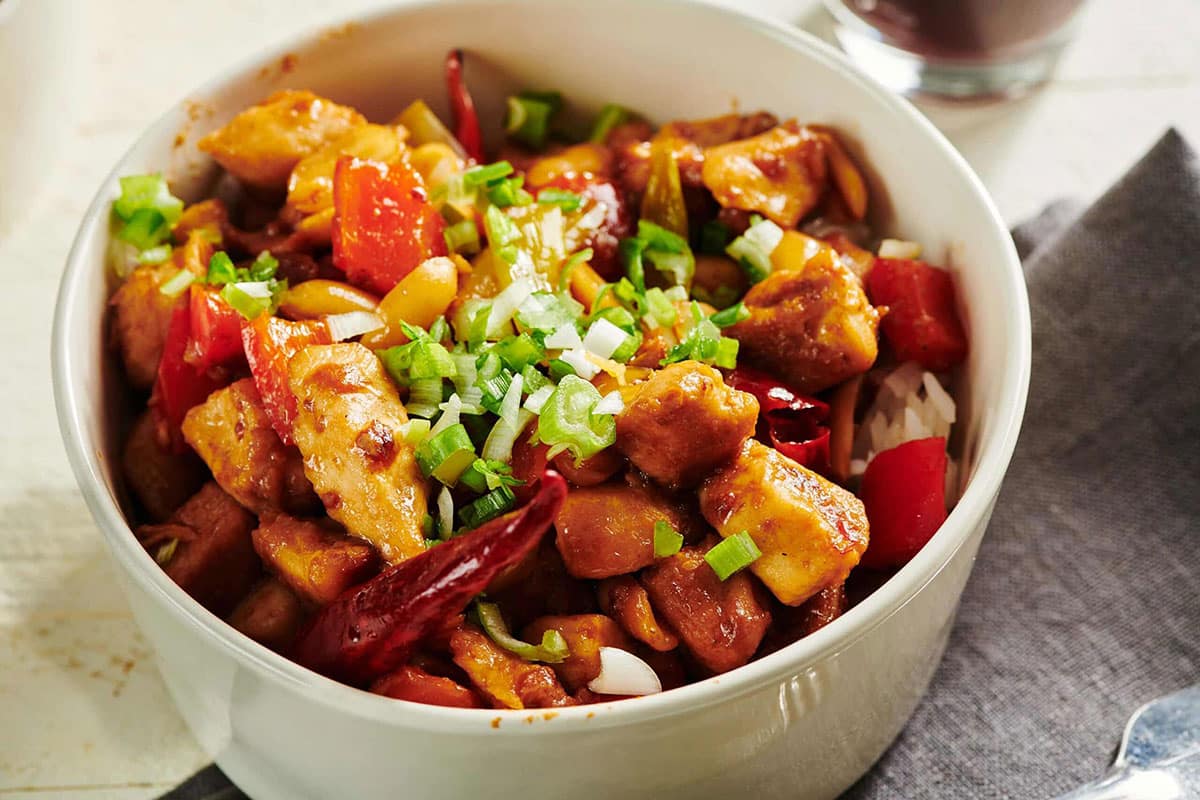 Kung Pao Chicken in white bowl on table.