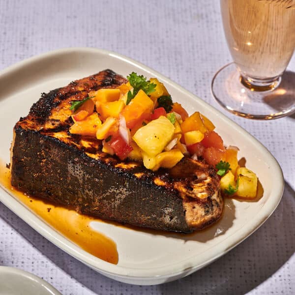 Grilled blackened swordfish on plate with fruit salsa.
