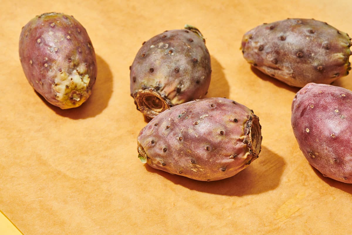 Fresh cactus pear fruits on yellow table.