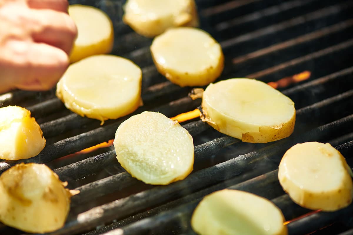 Placing potato slices on grill.