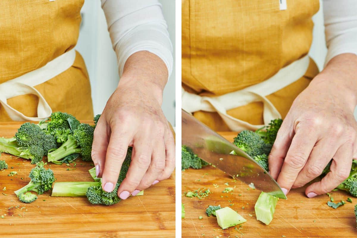 Woman cutting broccoli on wood board.