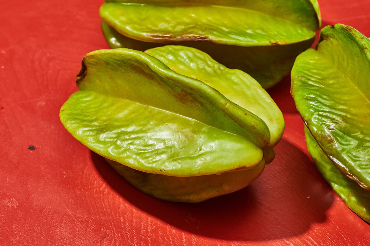 Fresh starfruit on red table.