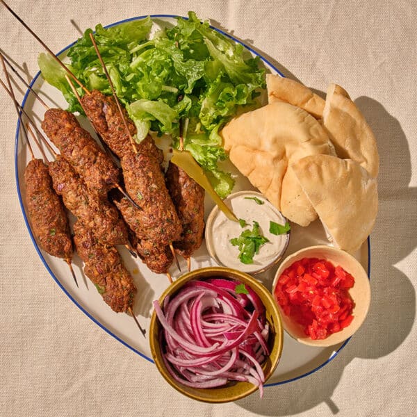 Lamb koftes on patter with pita, onions, lettuce, and garlic yogurt sauce.