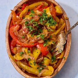 Homemade peperonata in bowl with serving spoon.