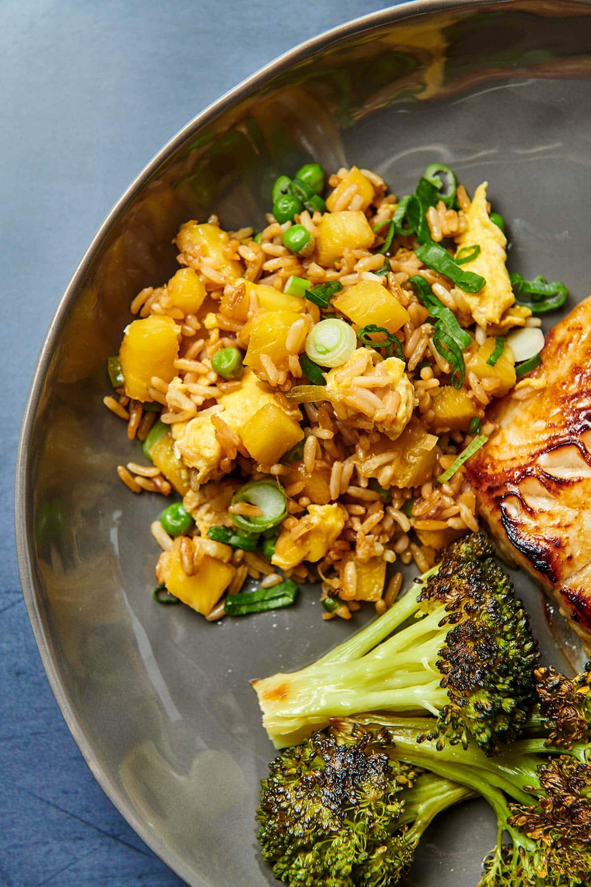 Pineapple fried rice on plate with broccoli.