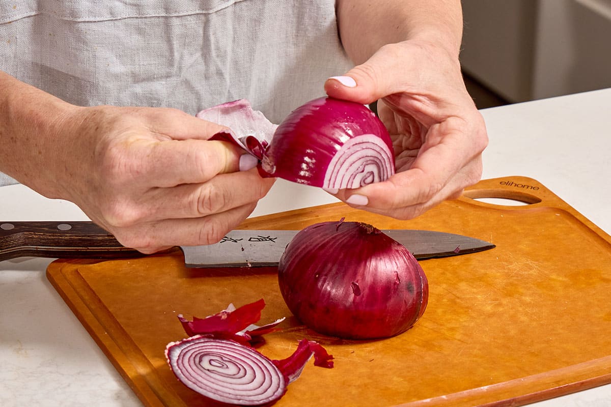 Peeling skin off red onion.