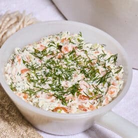 White bowl filled with loxed spread and dill garnish.