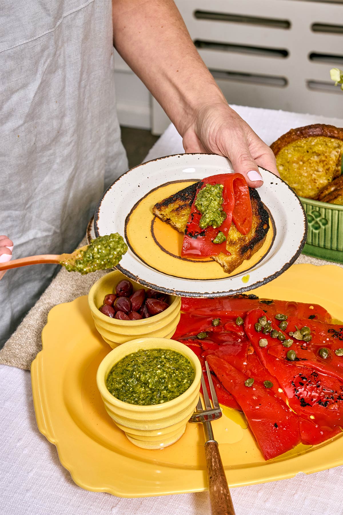 Woman spooning pepita pesto on appetizer plate.