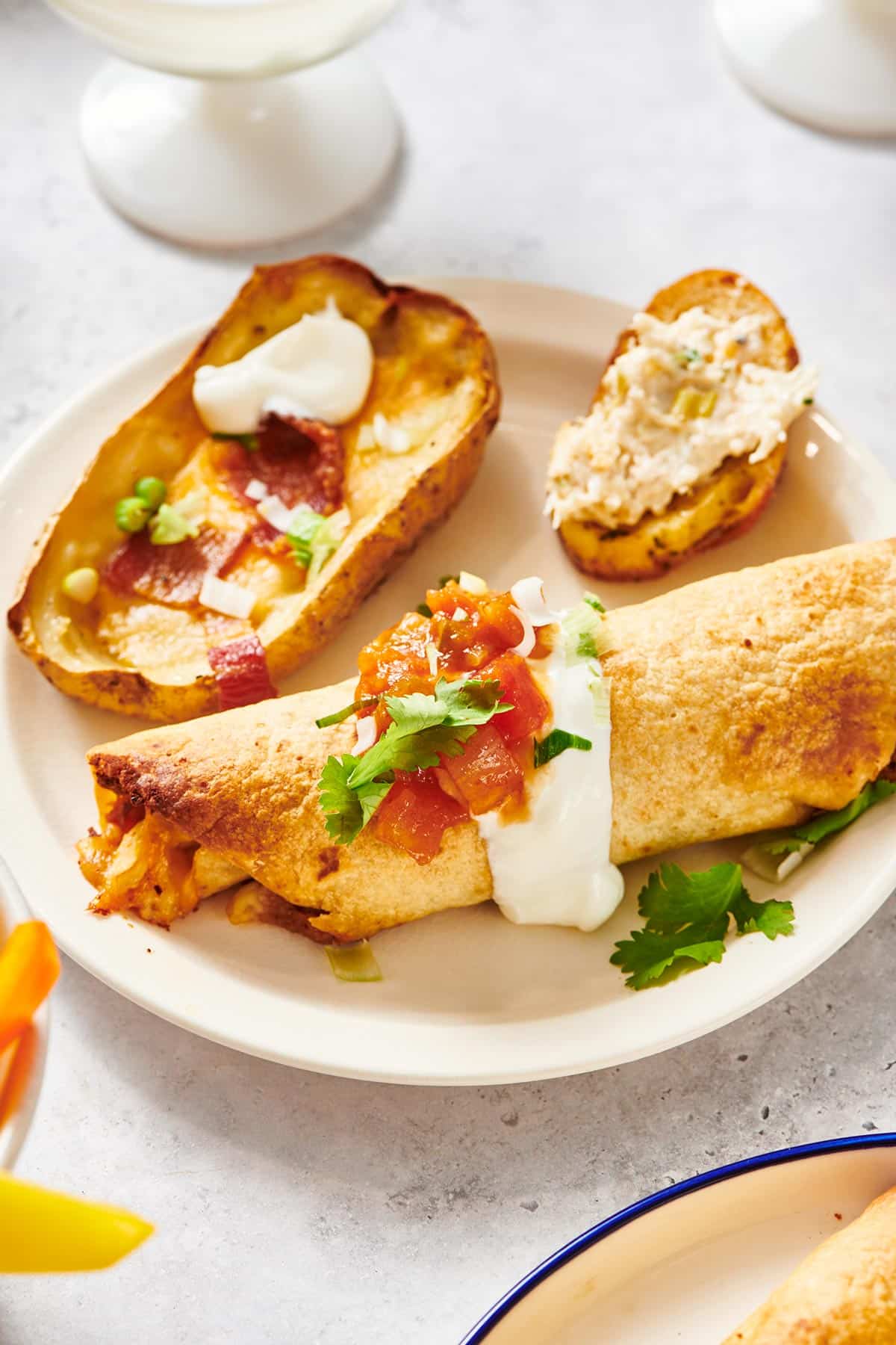 Chicken flauta on plate with side dishes.