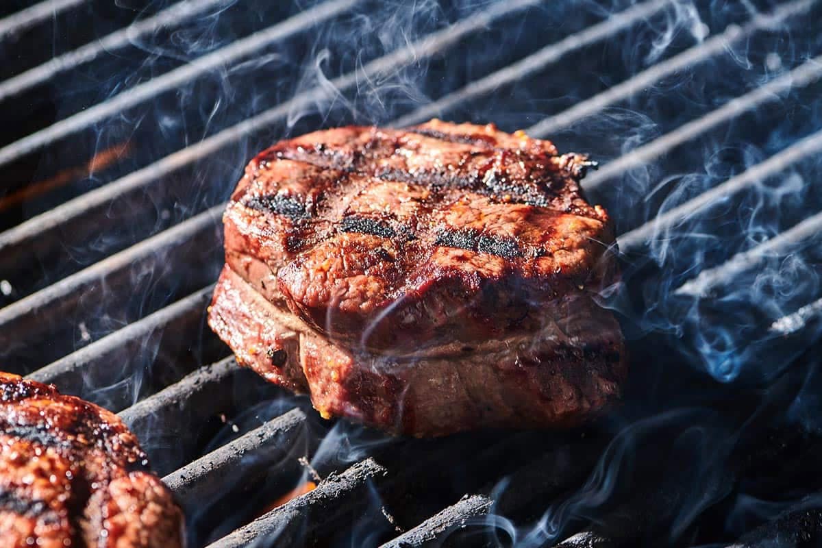 Cooked filet mignon steaks with cross-hatch grill marks on cutting board.
