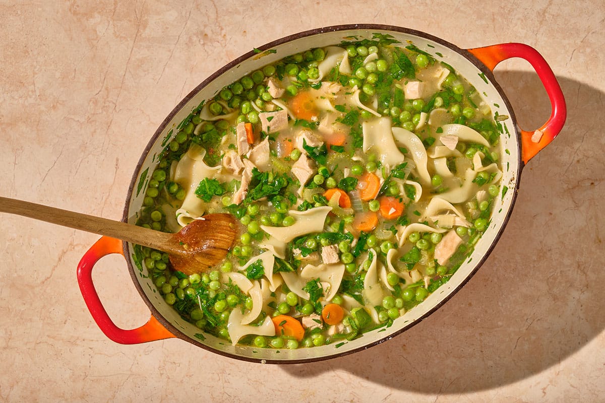 Leftover turkey soup in large bowl on table.