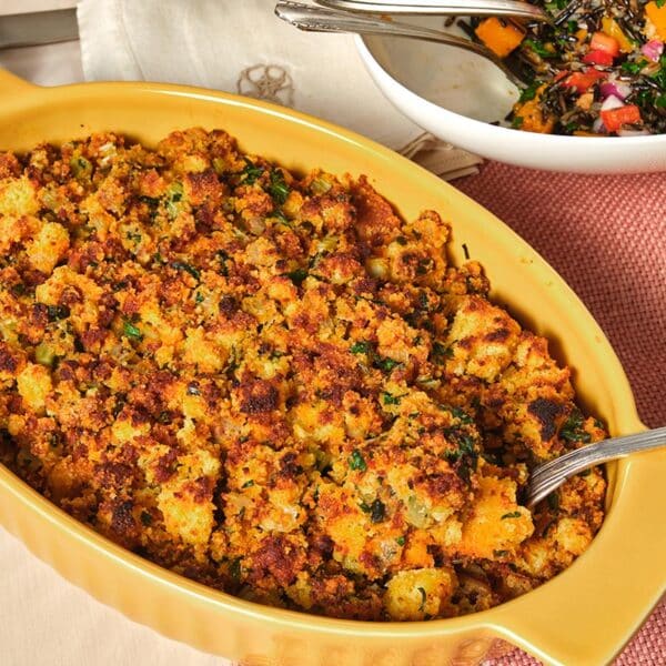 Chorizo cornbread dressing in yellow bowl on table.