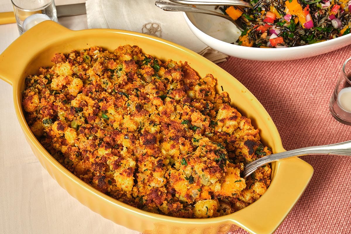 Chorizo cornbread dressing in yellow bowl on table.